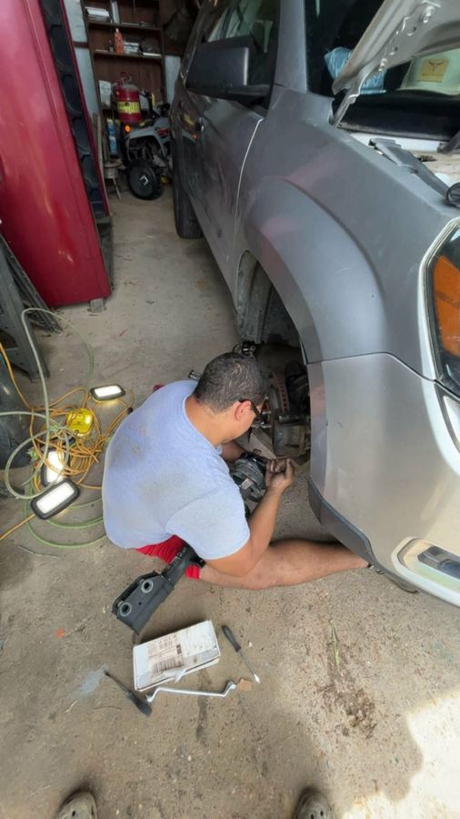 Jayden replacing front brakes on an SUV with the wheel removed